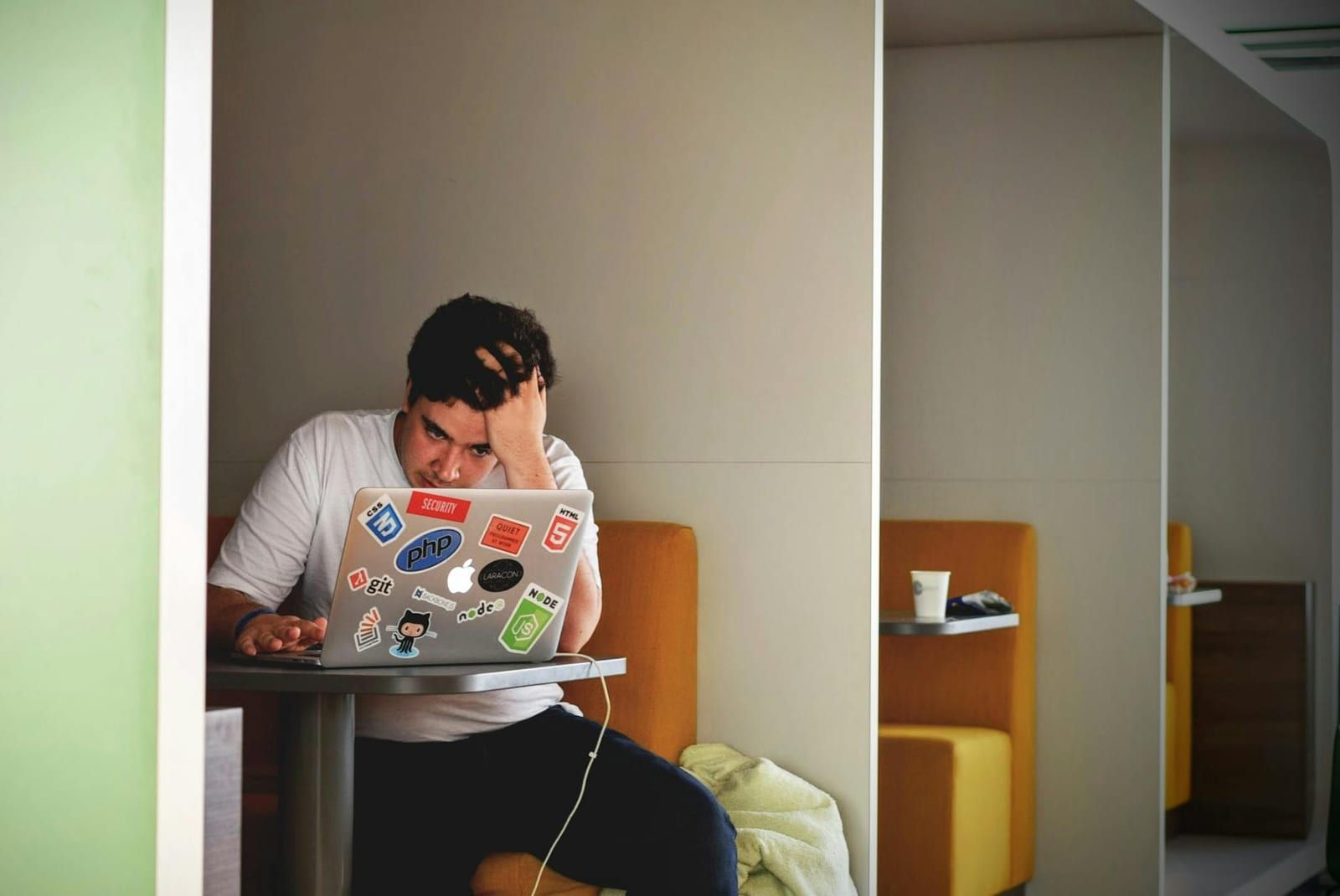 Frustrated person working at laptop. Photo by Tim Gouw on Pexels.